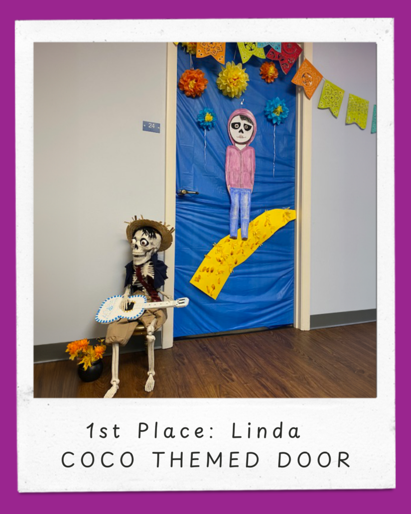 This door is themed to the Disney movie, Coco, and Dia de los Muertos (Day of the Dead). The door is covered in royal blue paper, with the main character, a boy named Miguel, painted as a skeleton, dressed in a pink hoodie and blue pants. He is crossing over a yellow bridge to find his great great grandfather in the Land of the Dead. Brightly colored paper flowers (orange, yellow, and blue) are placed around the top and sides of the door. Above the door, there are colorful papel picado banners, which are traditional Mexican decorative paper cutouts. Next to the door, on the floor to the left, there is a skeleton figure (representing Miguel’s great great grandfather) seated on a small bench, dressed in a brown hat, black vest and brown shorts, holding a white guitar, with a pot of marigold flowers to the left. At the bottom of the image, there is a white frame with purple edges, featuring the text: "1st Place: Linda, Coco themed door"