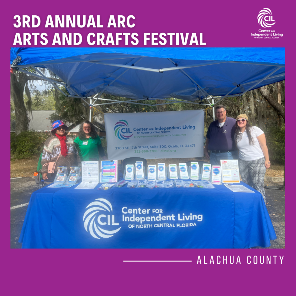 The image shows Sada, Kevin, Claudia, and a consumer standing in front of a booth at the 3rd Annual ARC Arts and Crafts Festival. The booth is set up by the CIL, and it features informational brochures, resource materials, and a banner with the CIL logo. The group includes three individuals—two women and one man—who are smiling and posing in front of the booth. The booth is set up under a blue canopy, and the background shows trees and sunny weather. The photo highlights the event’s atmosphere of community engagement and resource sharing.