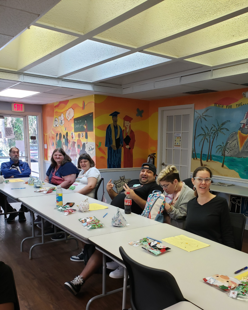 ILS participants at the Gainesville Holiday Party smile and enjoy their time together, with gift bags and materials for crafting on the table.