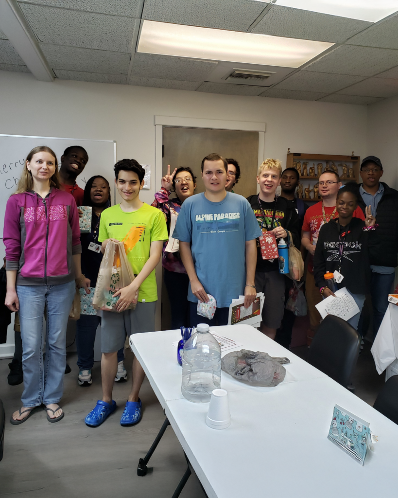 A group of ILS participants and staff smile together at the Ocala Holiday Party, holding their gift bags and celebrating the season.